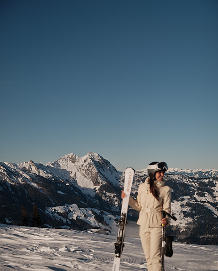 Woman with Ski on top of a mountain