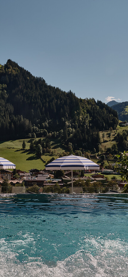 Outdoor infinity pool in the Adults Only Spa area with views into the Großarltal valley at the 5 star hotel in the Salzburger Land
